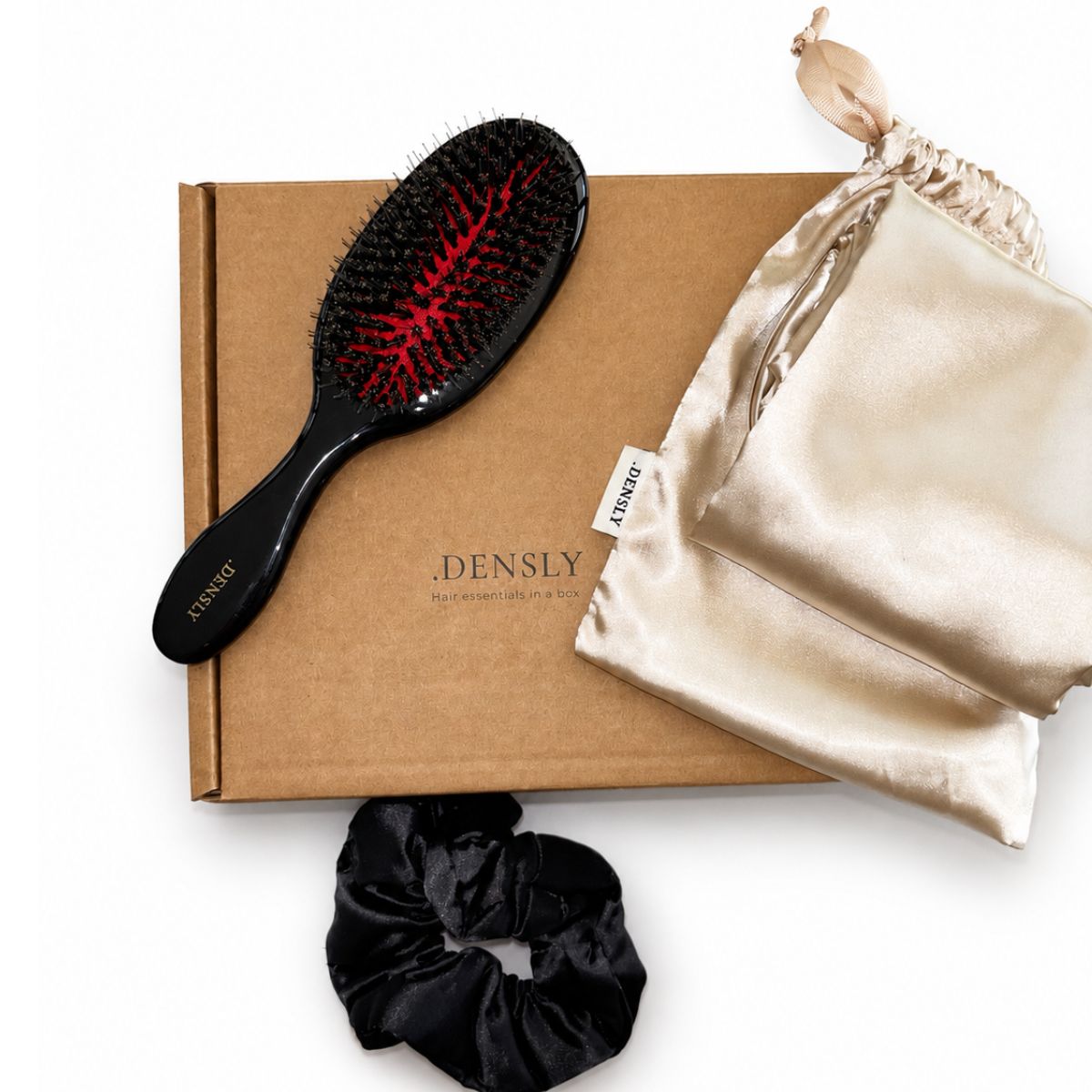 Accessoires cheveux DENSLY pour la rétention des longueurs : brosse en poils de sanglier, taie satin et scrunchie.