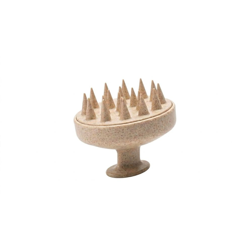 Brosse massante pour cuir chevelu en silicone beige avec picots souples et incurvés, exfolie en douceur, stimule la circulation sanguine, favorise la pousse des cheveux et réduit les démangeaisons. Accessoire disponible dans la box Densly